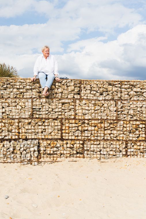 Jules Whale on top of wire cage of Dorset beach pebbles