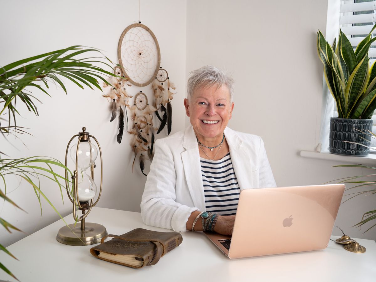 Jules whale sat at a desk with her laptop in front her with plants either side.