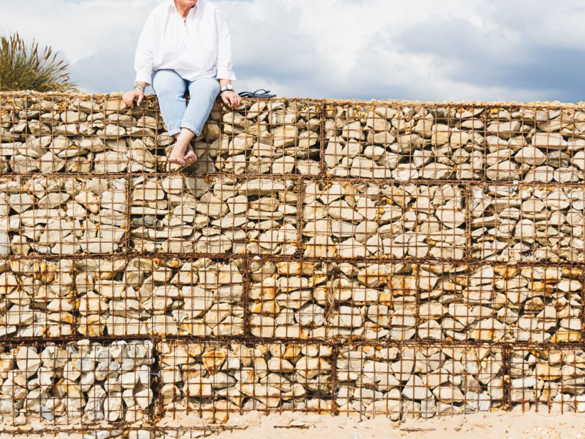 Jules Whale on top of wire cage of Dorset beach pebbles